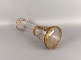 a gold and white glass vase with a gold decoration on it