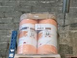 a large stack of orange rolls of toilet paper on a pallet