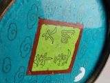 a close up of a blue vase with a green label on it
