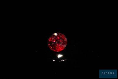 a close up of a red diamond on a black surface