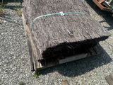a pile of wood sitting on the ground next to a pile of other wood
