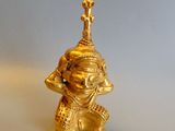 brass figurine of a man with a cross on his head