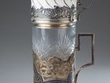 a glass cup with a gold decoration on it