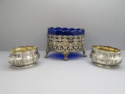 trois objets en verre argenté et bleu posés sur une table