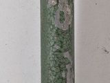 a green pole that has a clock on top of it