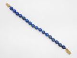 un bracelet en perles de lapis-lazuli bleu orné d'une croix en or