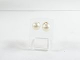 une paire de boucles d'oreilles à clous en perles, présentée dans une boîte transparente posée sur un fond blanc