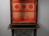 an old wooden cabinet with a red and gold design on it
