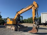 an orange excavator sitting on top of a gravel field