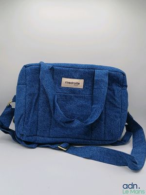 Le petit sac bleu est posé sur une surface blanche.