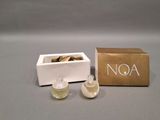 two small bottles of perfume sitting next to a box