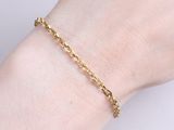 a close up of a woman ' s hand wearing a gold chain bracelet