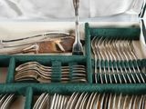 silverware in a green case on a white surface with a fork and spoon