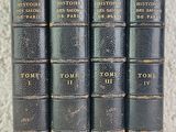 a set of five old books sitting on top of a table