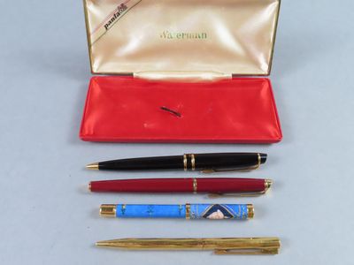 trois stylos et un étui à stylos posés sur une table