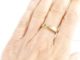 a woman ' s hand with a gold ring on it
