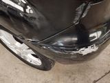a car that has been dented and is parked on the side of the road