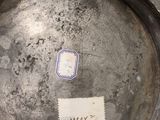 a silver vase with a stamp on it sitting on a table