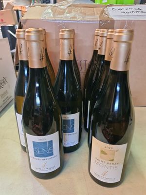 six bouteilles de vin sont posées sur une table devant un carton
