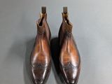a pair of brown shoes sitting on top of a table