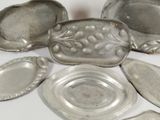 a lot of silver dishes on a white table