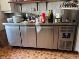 un comptoir en acier inoxydable sur lequel sont posées plusieurs bouteilles