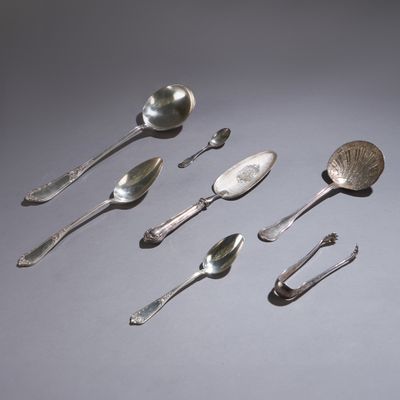 Plusieurs cuillères en argent et cuillères-cuillères sont alignées en rangée
