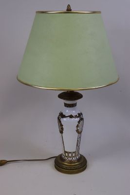 une image représentant une lampe avec un abat-jour vert posée sur une table