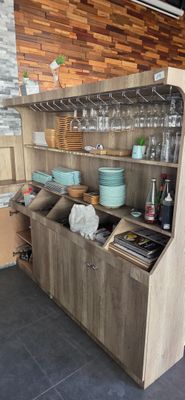 a kitchen with a wooden cabinet and a counter with dishes on it