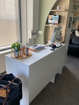 a white desk with a laptop and a bag on it
