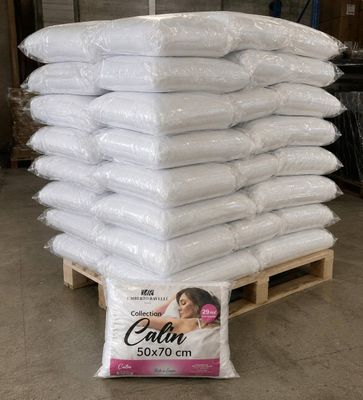une pile d'oreillers posée sur une palette dans un entrepôt