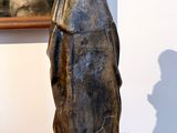 a statue of a man standing on a table in front of a painting
