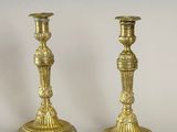 pair of antique brass candlesticks on a white background