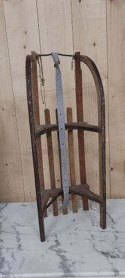 une luge appuyée contre un mur en bois