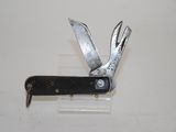 a small knife with a black handle on a white surface