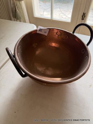 a copper bowl sitting on a counter in front of a window