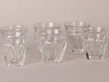 four clear glass cups are lined up on a white surface