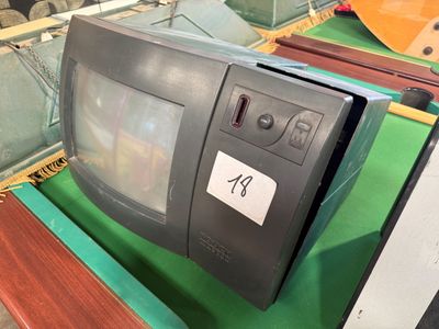 un vieux téléviseur posé sur une table verte