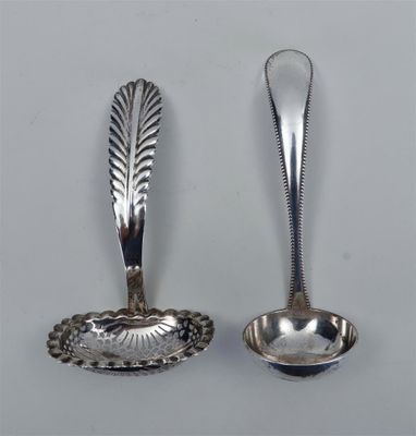 deux cuillères en argent et une cuillère posées sur une surface blanche