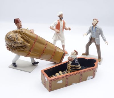 trois figurines représentant des personnes debout à côté d'une boîte