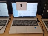 trois ordinateurs portables posés sur une table en bois