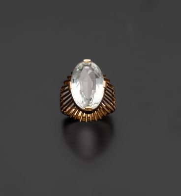 une bague en or sertie d'une topaze blanche ovale sur fond noir