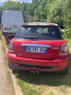 une petite voiture rouge garée sur le bord de la route