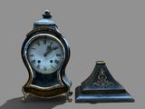 a small clock sitting next to a smaller clock on a table