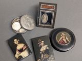 trois portraits miniatures de femmes et une pièce de monnaie posés sur une table
