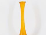 vase en verre jaune avec un socle marron sur fond blanc