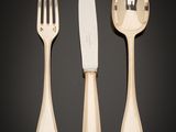 a set of three forks and a knife on a black background