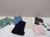 a white table topped with lots of clothing on it