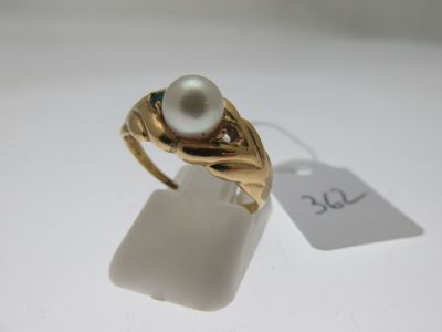 une image représentant une bague en or sertie d'une perle et d'un diamant