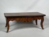 une table basse ancienne avec un plateau et des pieds en bois